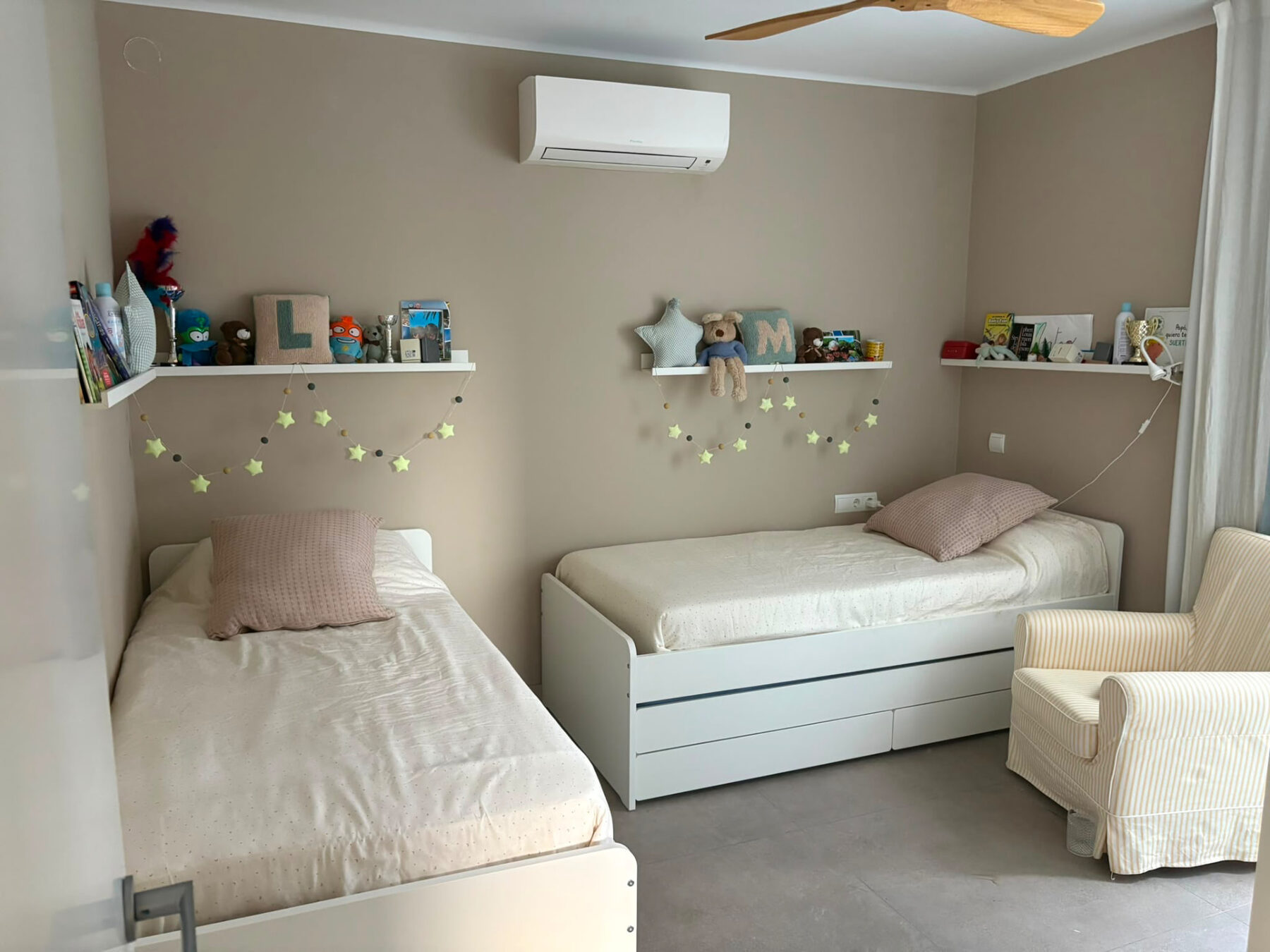 Children’s bedroom with two white beds, beige walls and white shelving — Mediterranean Home on the Costa Brava